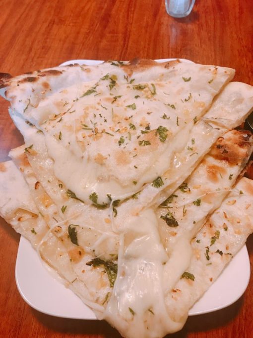 Soft unleavened bread stuffed with cheese and garlic cooked in tandoor.