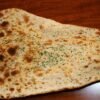 Garlic naan oven(tandoor) backed flat bread topping with butter and garlic